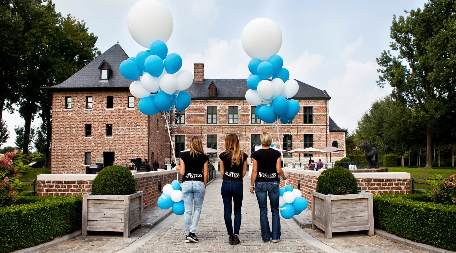 Hostesses met ballonnen voor een kasteel